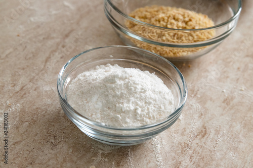 Healthy baking ingredients: sugar, grains of hazelnuts and crumbled biscuits. Bakery background frame.
