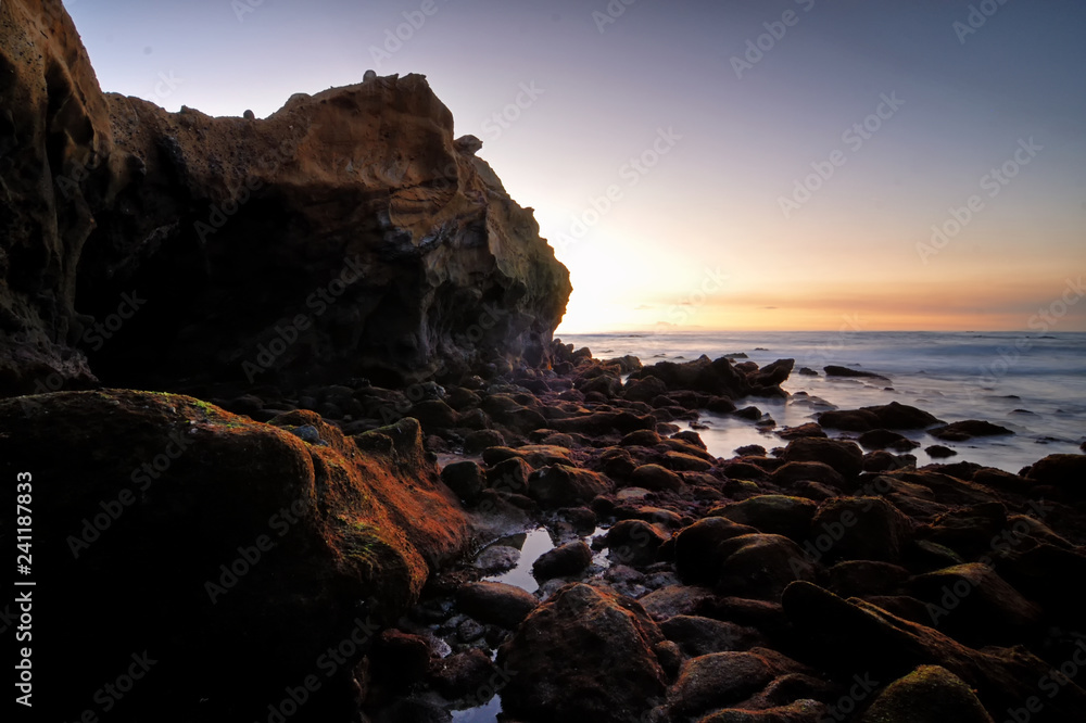 Rocky geological formations of the Laguna shore as sun sets and the blue hour sets in.