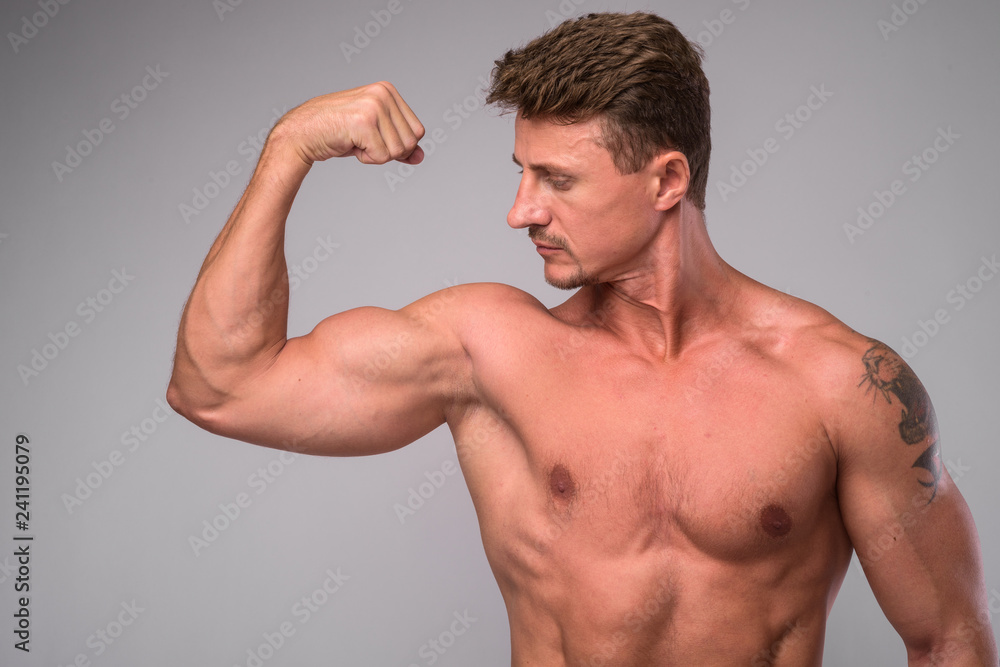 Muscular handsome bearded man shirtless and flexing muscle Muscular handsome bearded man shirtless and flexing muscle
