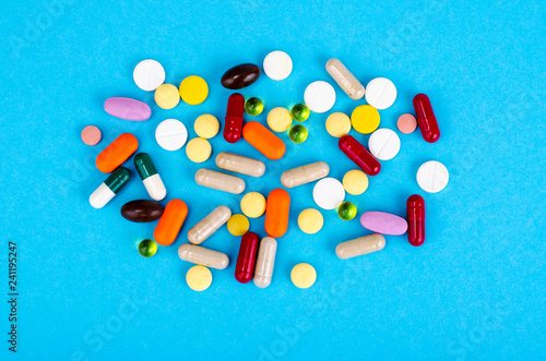 Photos Assorted pharmaceutical medicine pills, tablets and capsules on bright background