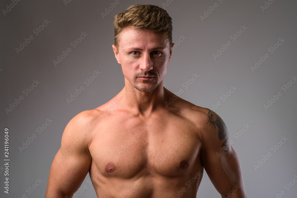 Fototapeta premium Muscular handsome bearded man shirtless against white background