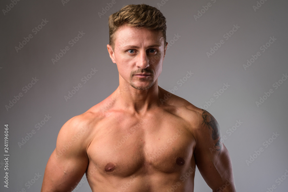 Fototapeta premium Muscular handsome bearded man shirtless against white background
