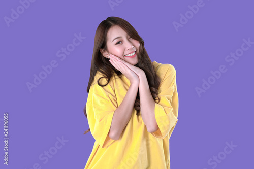 Asian woman wish love and happiness, yellow t-shirt clothing, purple background © AtidChalermsong