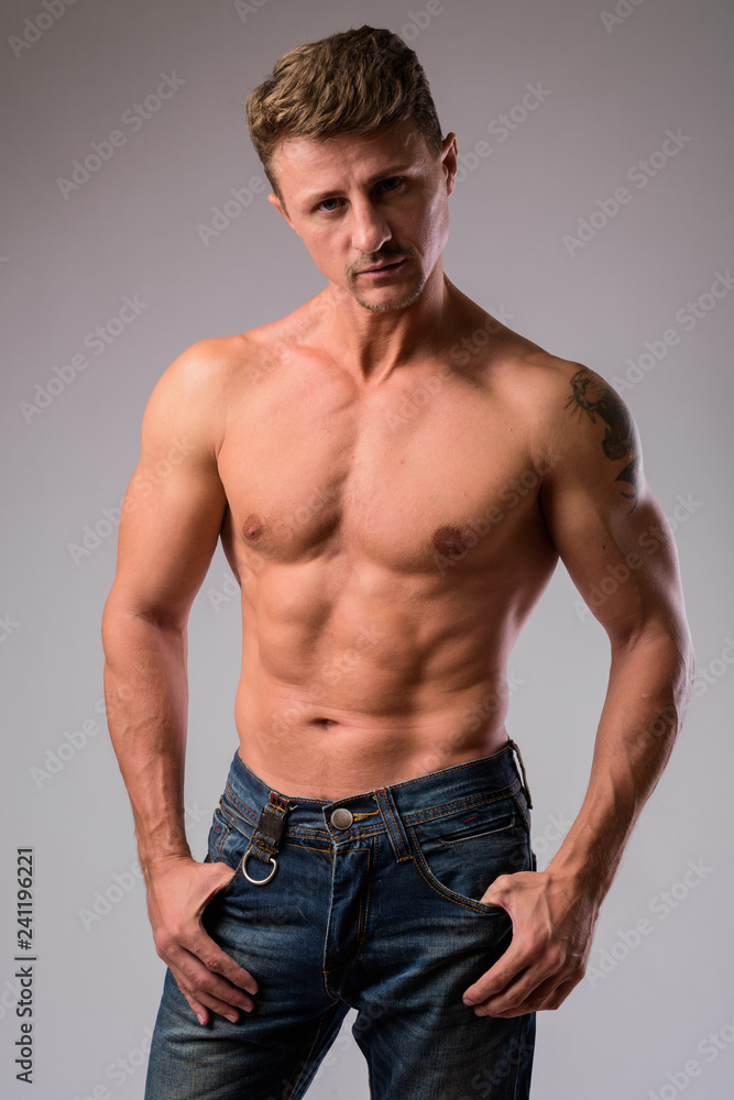 Muscular handsome bearded man shirtless against white background