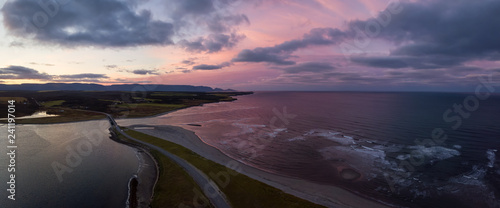 Aerial panoramic view of a beach on the Atlantic Ocean Coast during a dramatic sunrise. Taken in Codroy Valley, Newfoundland, Canada.