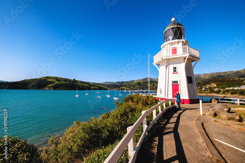 A beautiful lighthouse locate in Akaroa, New Zealand. This is a perfect holiday destination. It is popular among tourists, backpackers, and locals. One can enjoy clear blue sky, ocean, and shops. photo