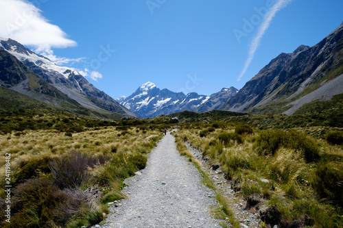 A long straight gravel road that leads to the famous breathtaking snow mountain in Mount Cook, New Zealand. The landscape is epic. There are snow mountain, glacier, alpine, rivers and valley.