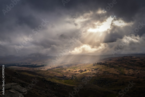 This amazing place is taken in Otago of New Zealand. It was a very cloudy day. The sun magically shines through a gap through the cloud producing amazing sun ray in the sky. It looks surreal.