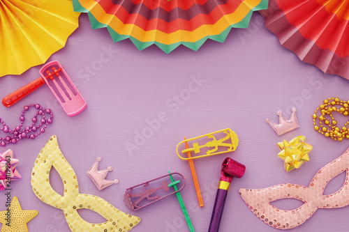 Purim celebration concept (jewish carnival holiday) over pink wooden background. Top view. photo