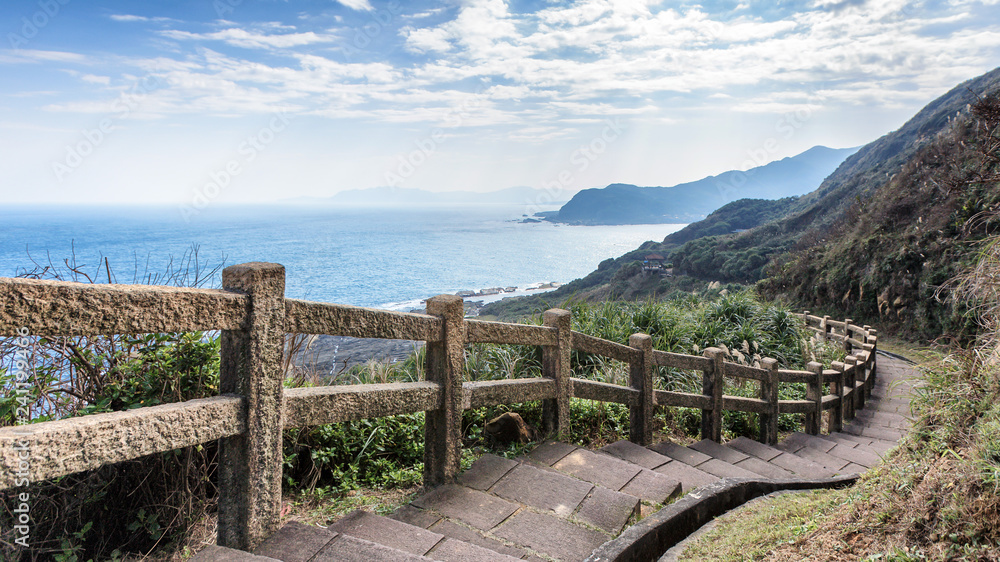 This stunning view was taken in a popular hiking track in Taiwan. The stairs lead downhills along the edge of the cliff. The scenery has mountains and ocean. Steep drop provide exciting to visitors.