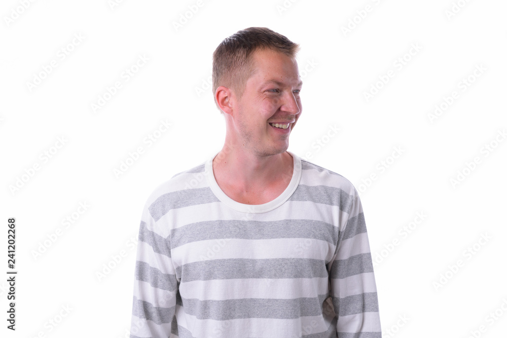 Young happy handsome man thinking and looking away isolated against white background