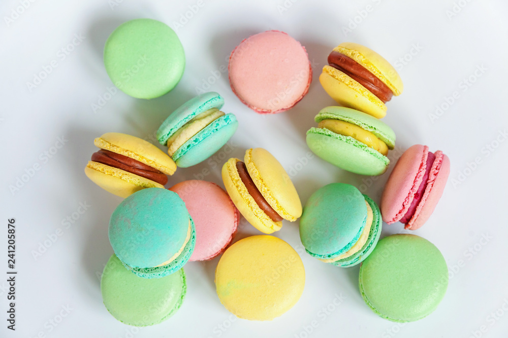 Sweet almond colorful pink, blue, yellow, green macaron or macaroon dessert cake isolated on white background. French sweet cookie. Minimal food bakery concept. Flat lay, top view, copy space Sweet almond colorful pink, blue, yellow, green macaron or macaroon dessert cake isolated on white background. French sweet cookie. Minimal food bakery concept. Flat lay, top view, copy space
