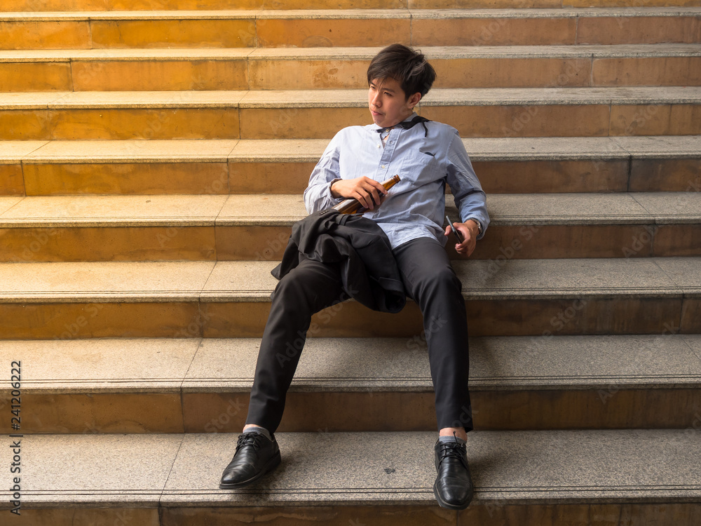Businessman sitting in outdoors park and stressed because of business work failure Businessman sitting in outdoors park and stressed because of business work failure