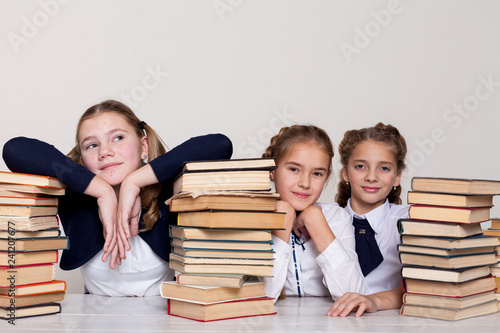 two girls schoolgirls sit with books at his desk on the lesson at school photo