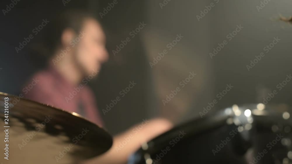 Long-haired drummers play drum kit in a dark room on a black background. Rock musician. Static plan. Wide angle Long-haired drummers play drum kit in a dark room on a black background. Rock musician. Static plan. Wide angle