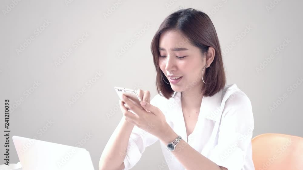 Young Asian girl use smartphone during working on computer laptop Young Asian girl use smartphone during working on computer laptop