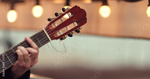 Close up 4k Footage of hand tune his guitar on the street with blurred background lights. - Video
