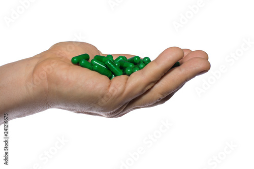 hand with green pills isolated on white background