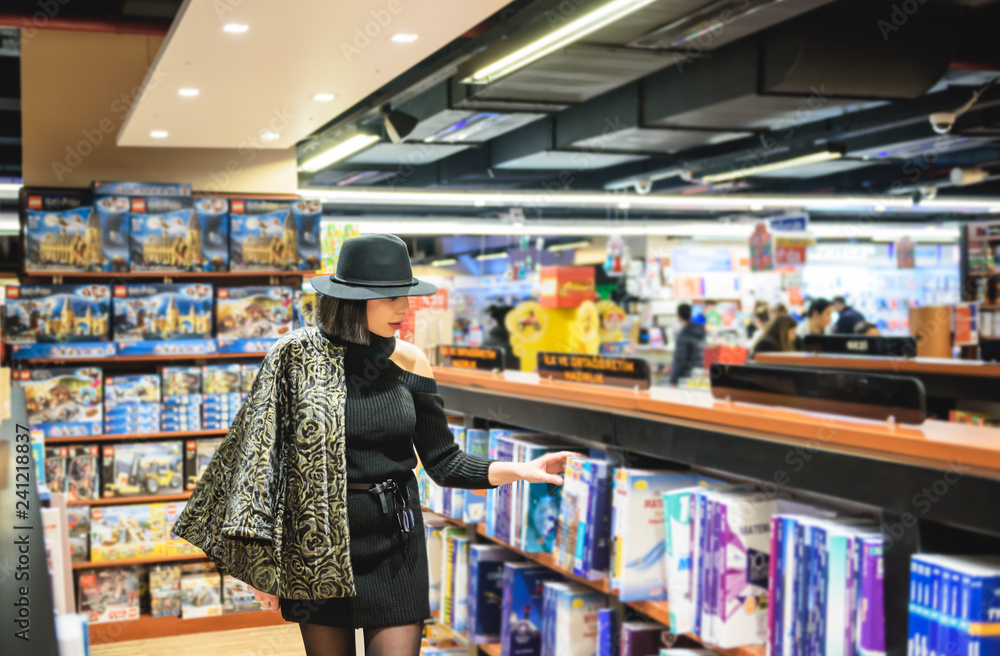 beautiful woman with black hat is in bookstore