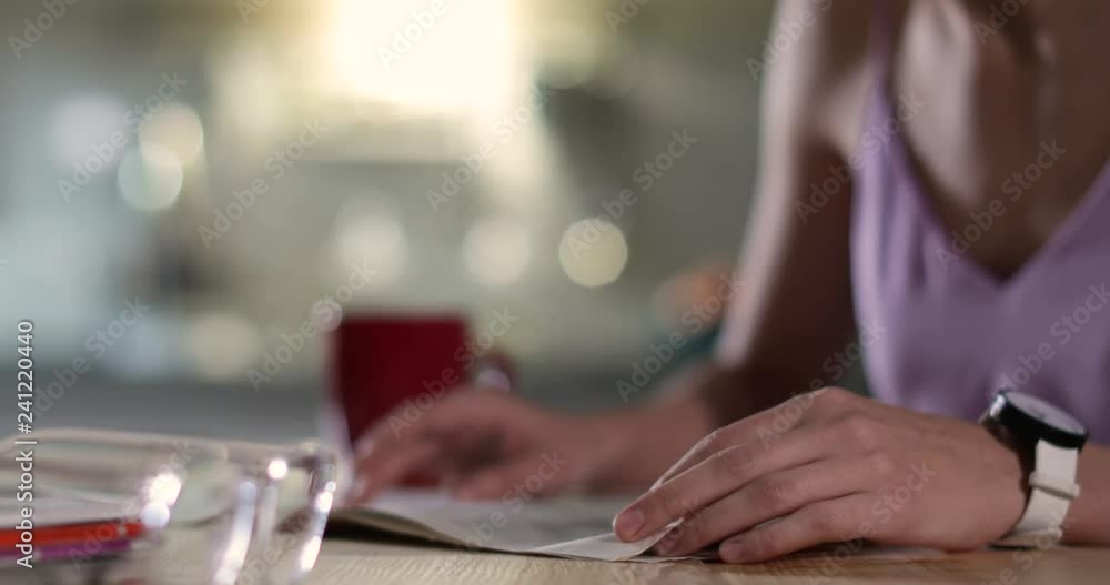 Woman reading newspaper at table indoors, closeup
Woman reading newspaper at table indoors, closeup