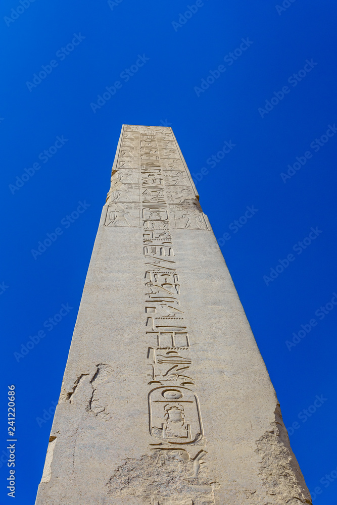 Granite obelisk against blue sky in a Karnak temple. Luxor, Egypt.