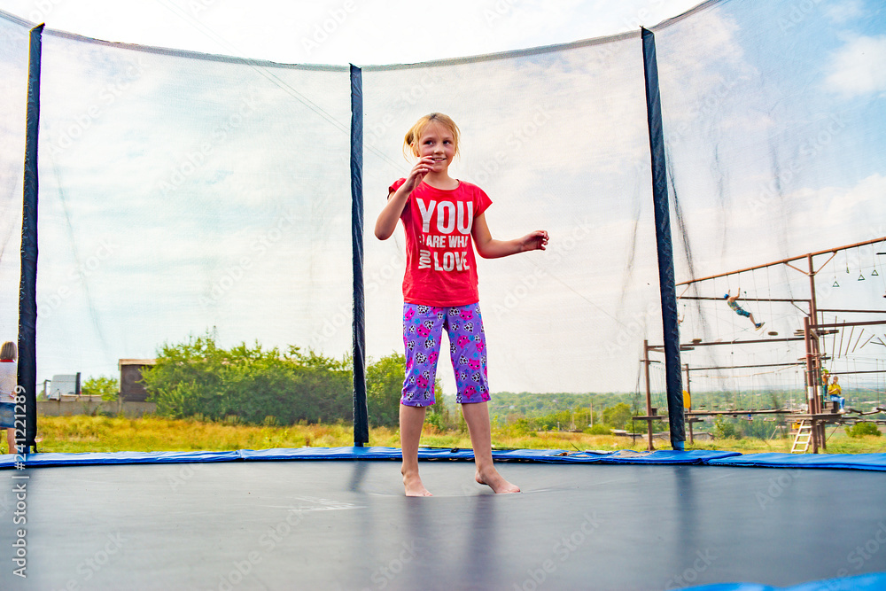A cheerful and happy child takes off from a trampoline jump.