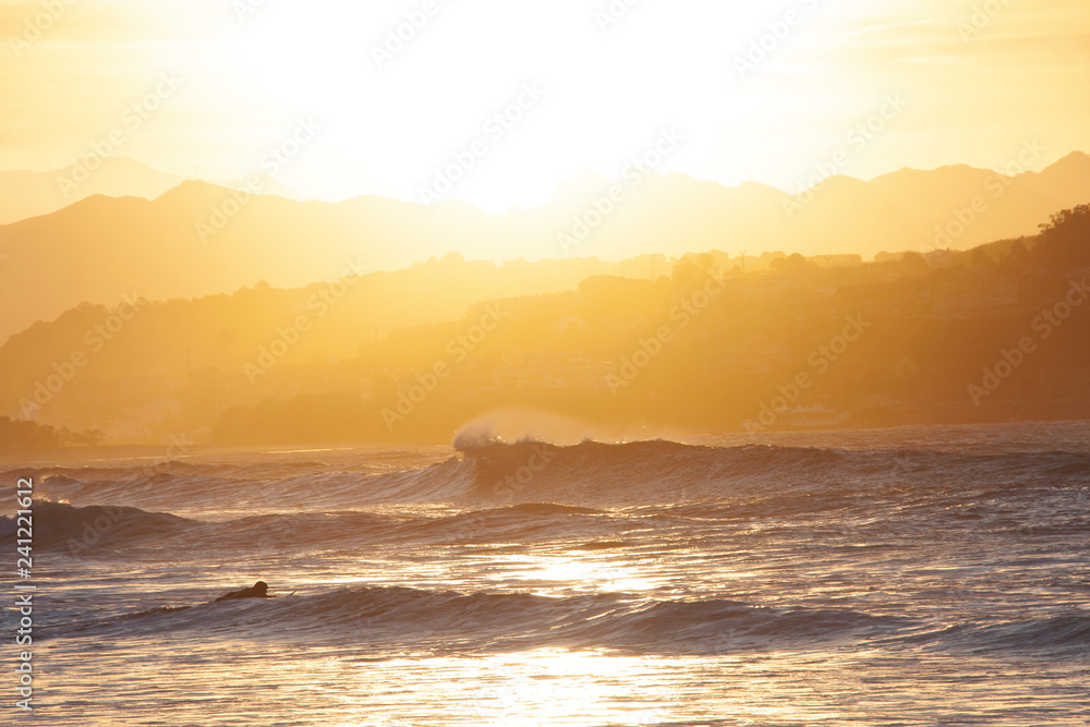 Surfista dentro del agua al atardecer en San Vicente de la Barquera Cantabría Surfista dentro del agua al atardecer en San Vicente de la Barquera Cantabría