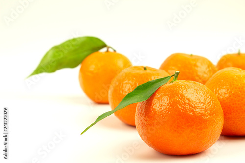 Ripe tangerines with green leaves on a white background