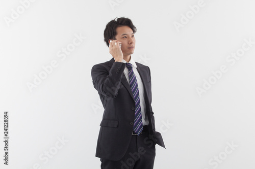 A young Asian business man talking on his phone