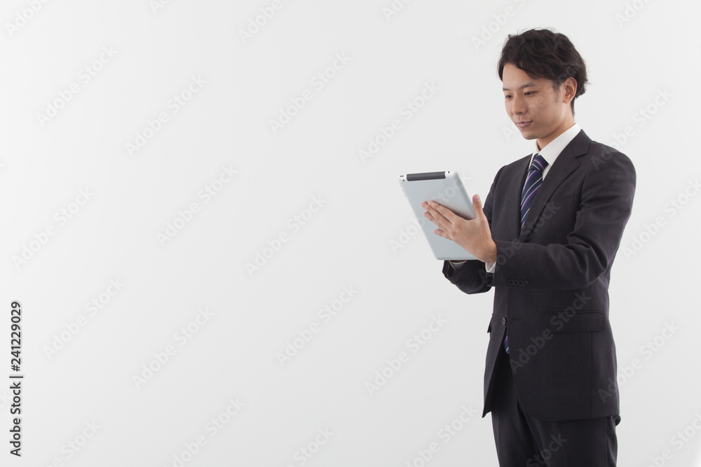 A young Asian businessman using a tablet A young Asian businessman using a tablet