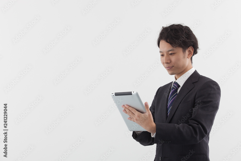 A young Asian businessman using a tablet A young Asian businessman using a tablet