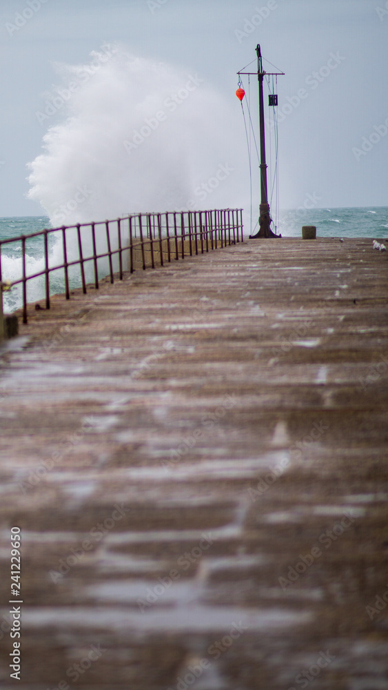 Obraz premium Big Waves Over a Pier
