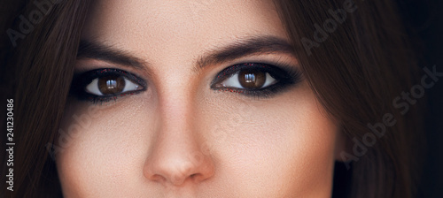 Beautiful eyes with bright makeup. Sexy view, sensual look. Female eyes with long eyelashes. Smoky eye makeup. Eyeshadows. Perfect eyebrows and long lashes. Cosmetics and make-up. Beauty concept