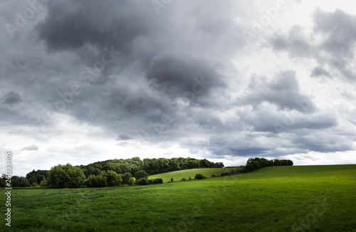rolling country landscape with clouds and a gentle ray of diffused light