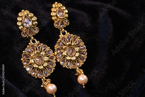 Pair of Golden earrings close up macro image on black background