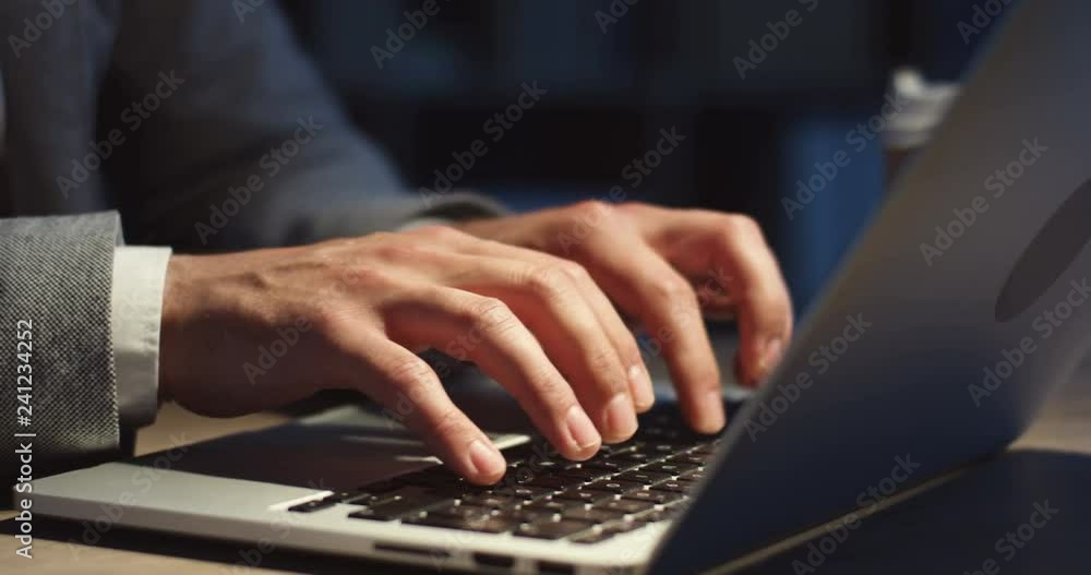 Close up of the Caucasian male hands tapping as typing on the laptop computer keyboard while he working at night. Close up of the Caucasian male hands tapping as typing on the laptop computer keyboard while he working at night.