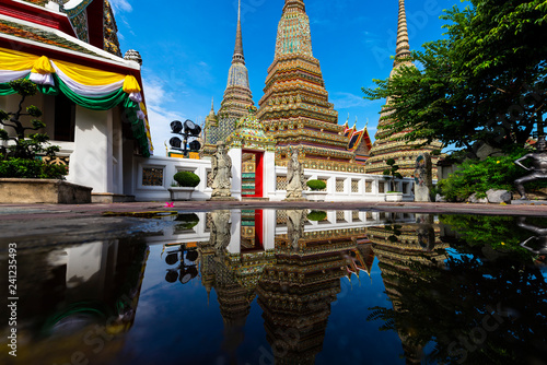 Very beautiful landmark of Bangkok, Thailand - Wat Pho during day time with water reflection effect by after raining.