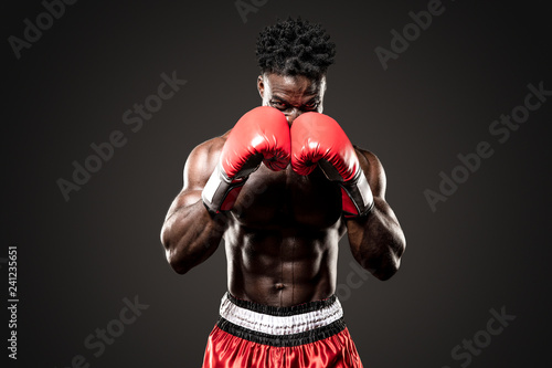 Фотография Muscular African American Black male sweaty boxer covers his head as he comes  t