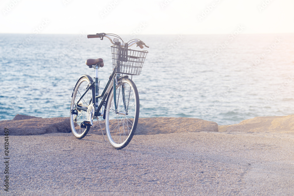 Fototapeta premium Bicycle parked on beach. Retro bike near the sea. Bike on the background of the sea horizon. Toning