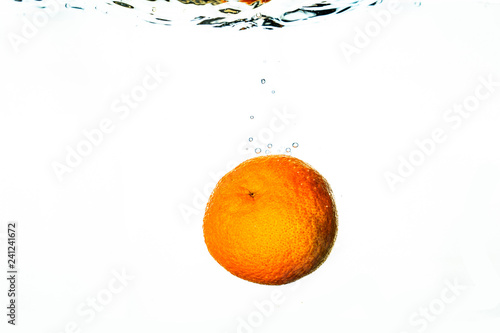 Fresh friut falls into water with splash