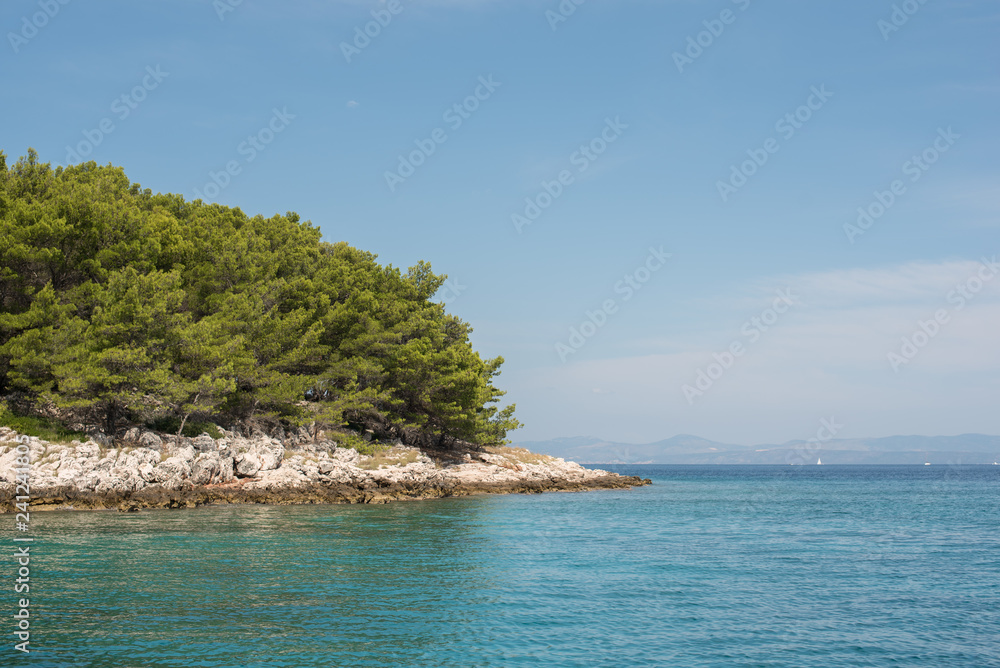 Beautiful coastline with green forest, stones and blue sky and sea water. Natural wallpaper. Adriatic coastline. Croatia. Mediterranean sea. Beautiful coastline with green forest, stones and blue sky and sea water. Natural wallpaper. Adriatic coastline. Croatia. Mediterranean sea.