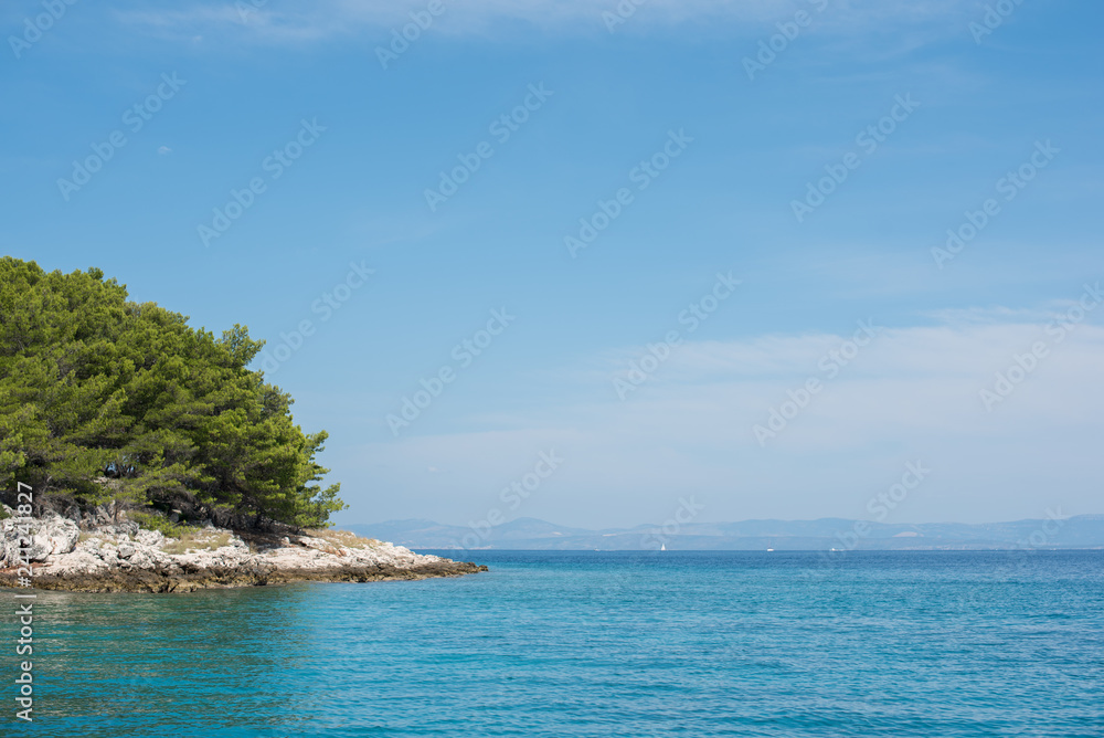 Beautiful coastline with green forest, stones and blue sky and sea water. Natural wallpaper. Adriatic coastline. Croatia. Mediterranean sea. Beautiful coastline with green forest, stones and blue sky and sea water. Natural wallpaper. Adriatic coastline. Croatia. Mediterranean sea.