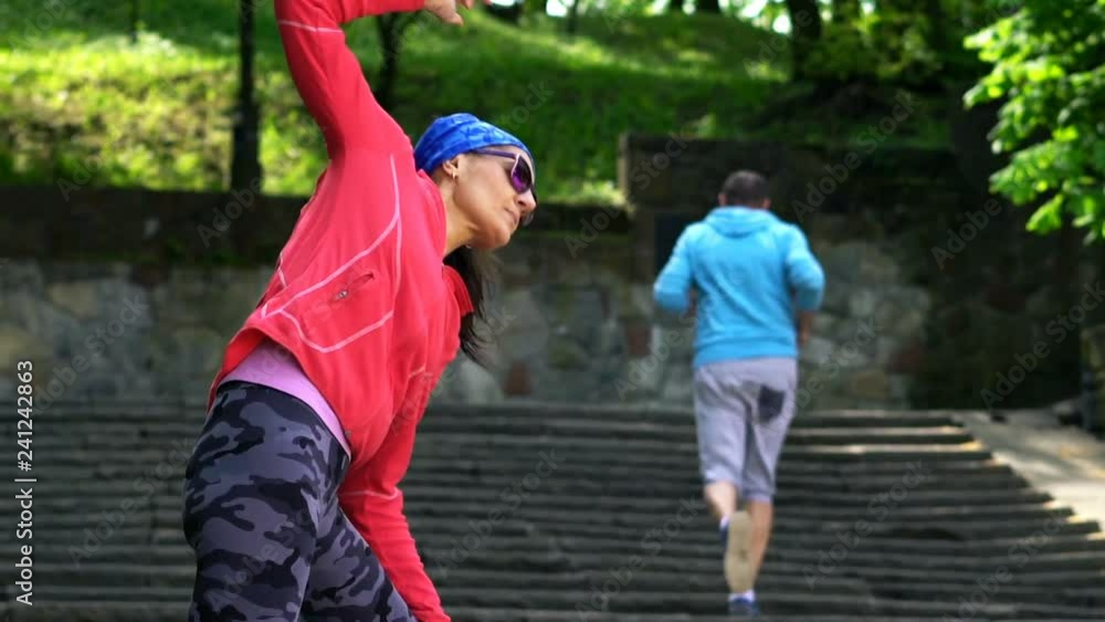 Young woman, jogger stretching in the city park Young woman, jogger stretching in the city park
