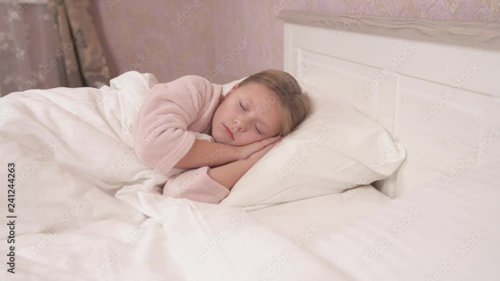 A long-haired girl in a gown is lying sidelong in the bed with her eyes closed and sleeping. The panning camera and it stops in the end A long-haired girl in a gown is lying sidelong in the bed with her eyes closed and sleeping. The panning camera and it stops in the end