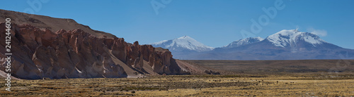 Snow capped peak of Volcano Guallatiri towering over the Lauca River valley high on the Altiplano of northern Chile in Lauca National Park. photo