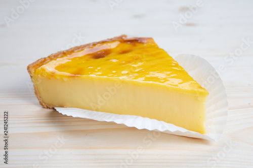 part of pastry flan in France on wooden table photo