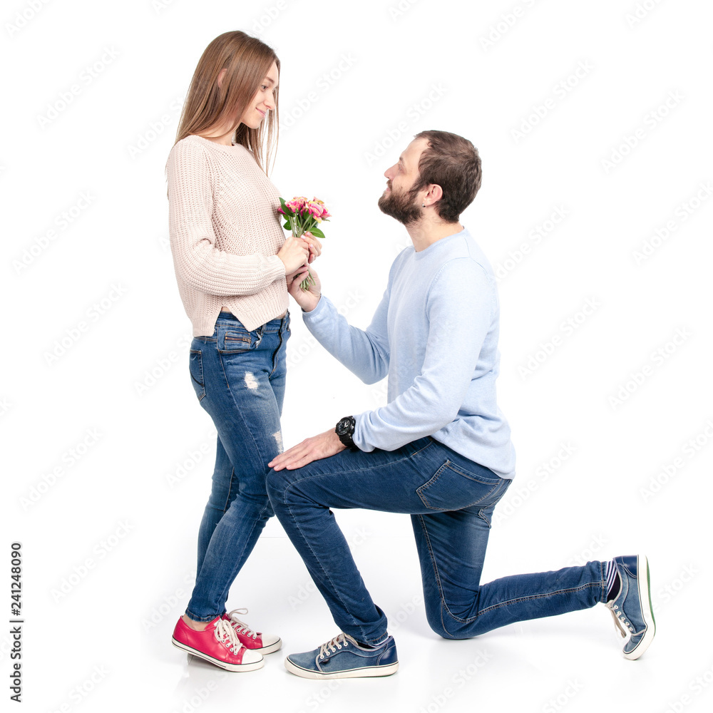 A handsome man gives a woman flowers on a white background. Isolation A handsome man gives a woman flowers on a white background. Isolation