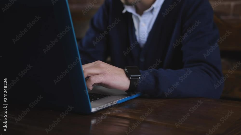 The man in glasses enthusiastically working on a laptop. A male writer is typing text on laptop keyboard, close-up. The man in glasses enthusiastically working on a laptop. A male writer is typing text on laptop keyboard, close-up.