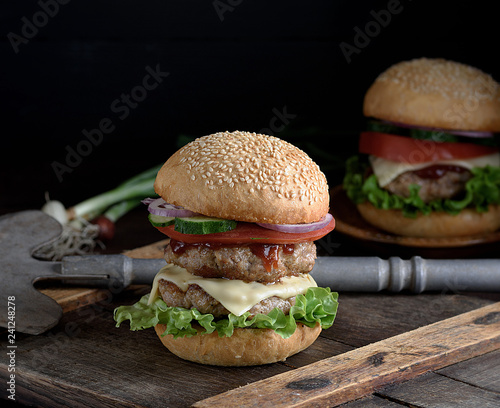  burger with two fried cutlets, cheese and vegetables