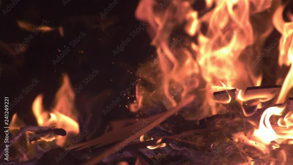 Dropping wood into flaming fire slow motion Dropping wood into flaming fire slow motion